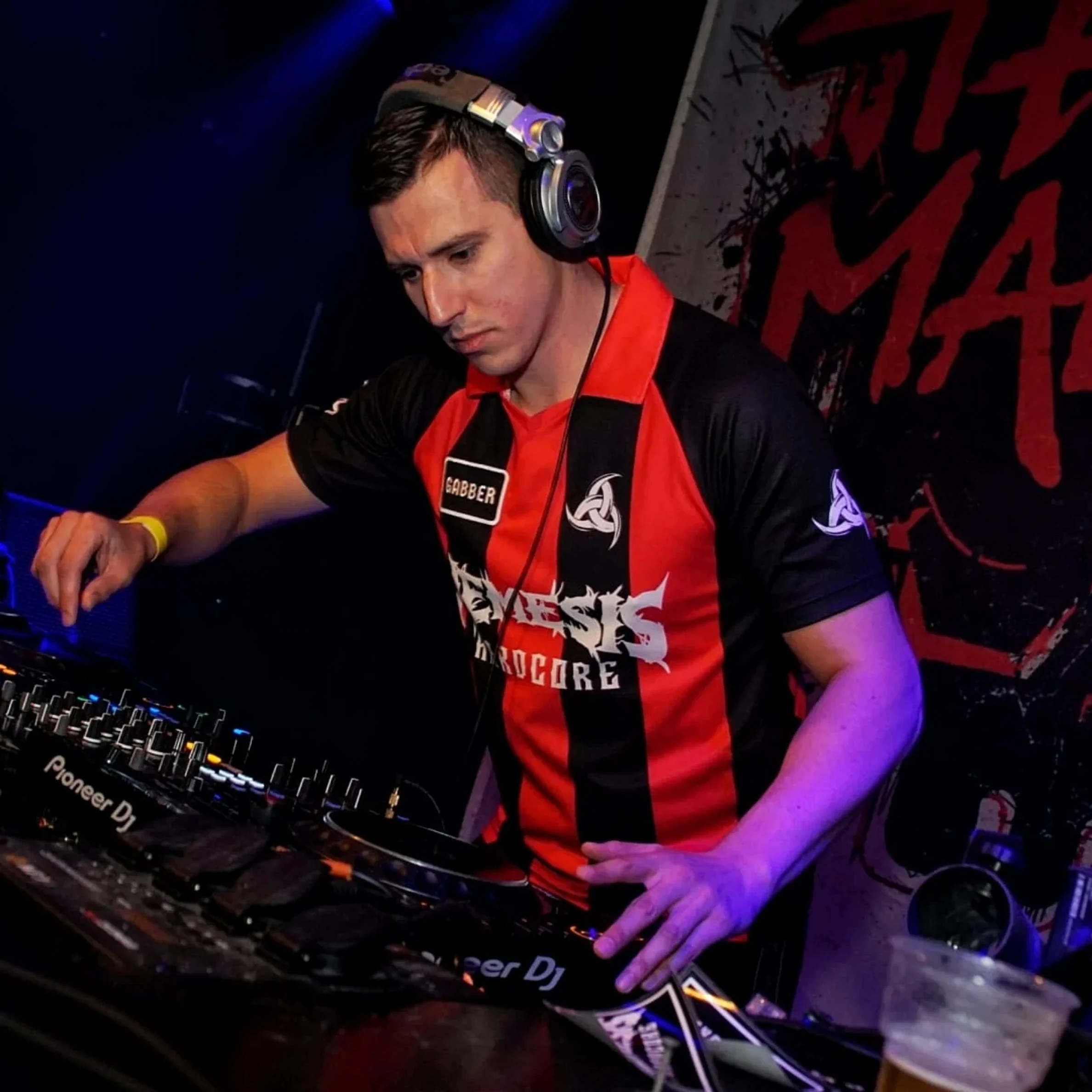 Nemesis Hardcore focused behind the decks during a live set